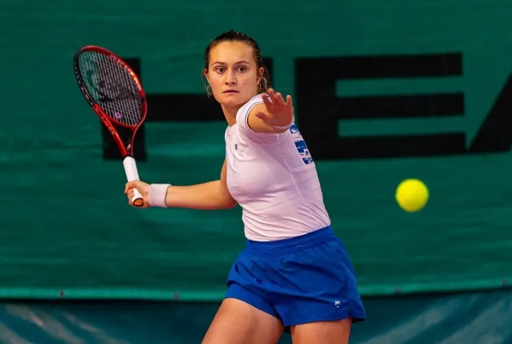 Astrid Cirotte frappe un coup droit, concentrée sur la balle